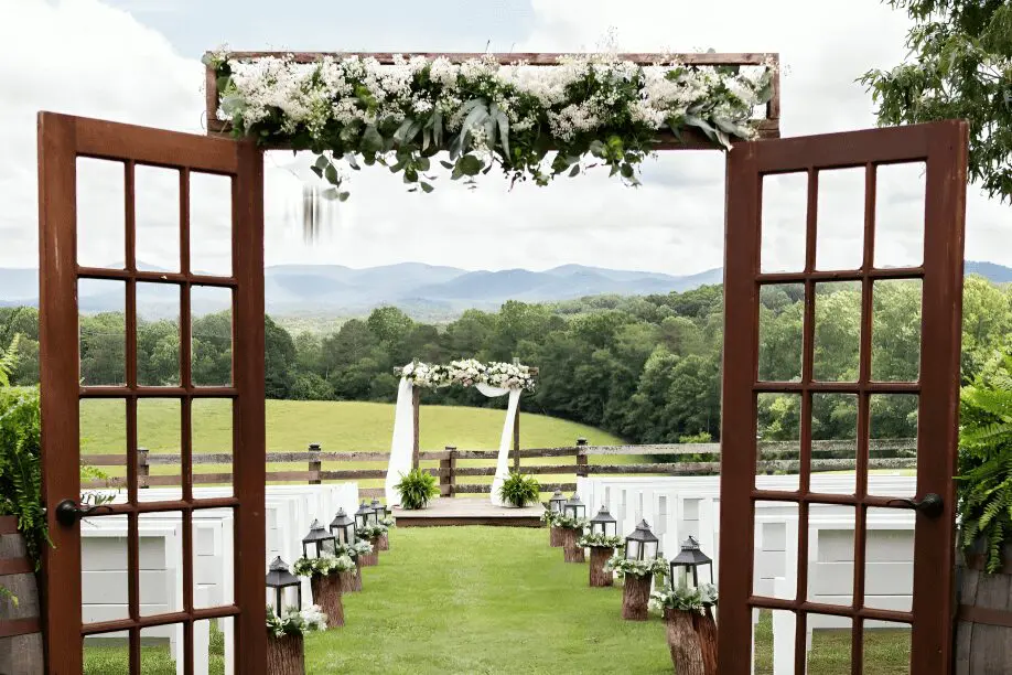 Rustic outdoor wedding ceremony with mountains.