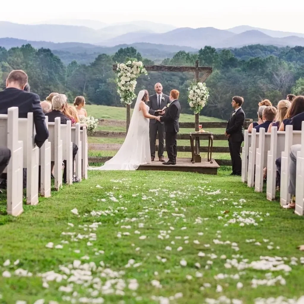 Outdoor wedding ceremony with scenic mountain backdrop.